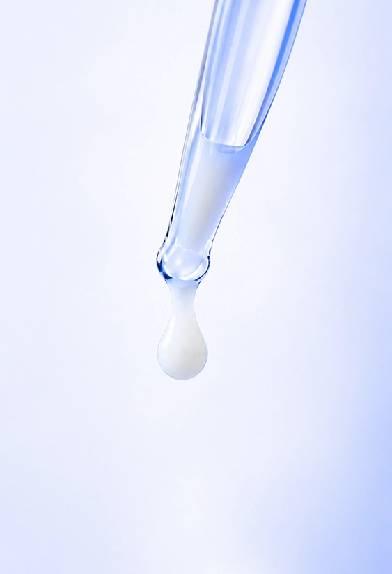 Close-up of a liquid droplet on a glass pipette in a clinical laboratory environment